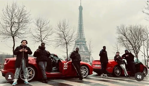 Des jeunes de l’association devant une Ferrari, au pied de la tour Eiffel.